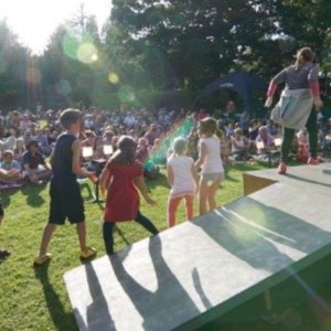Four young actors can be seen performing outdoors in a Heartbreak show on a sunny day.